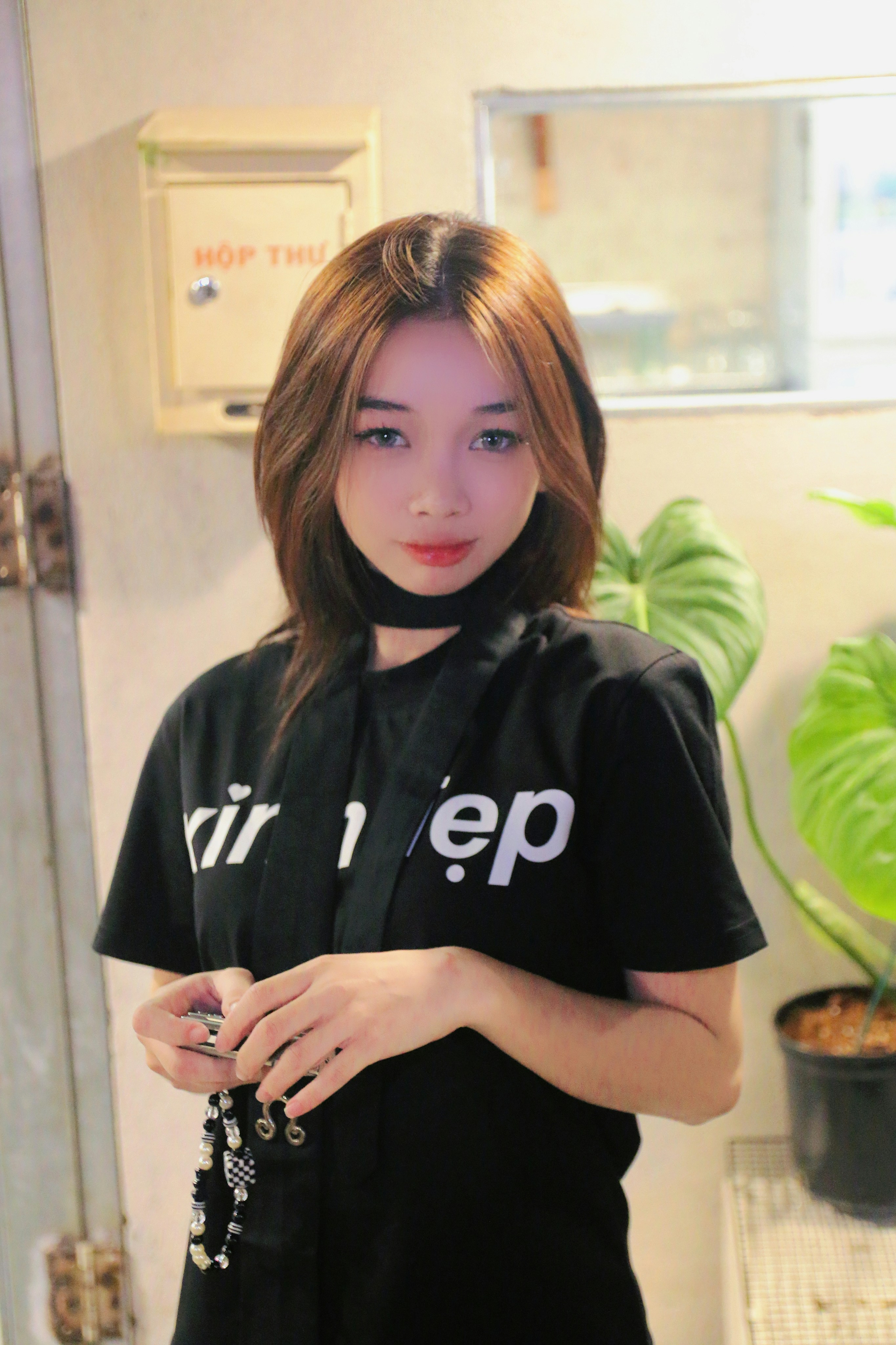 a woman in a black shirt standing in front of a mirror